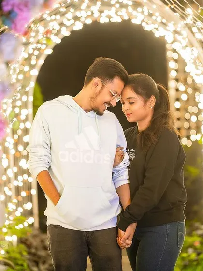 A tender moment between a couple in a tunnel of lights, creating a romantic and magical atmosphere.