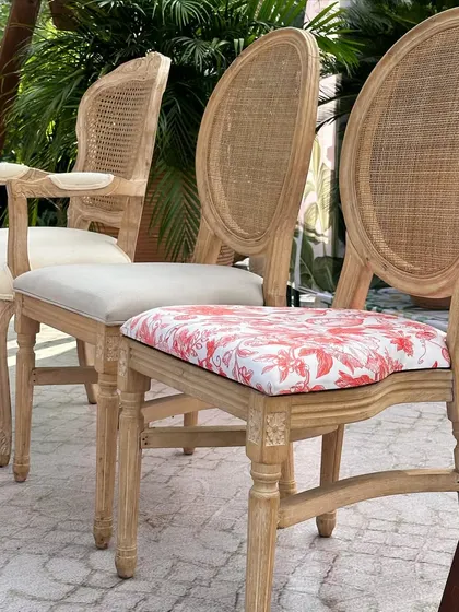 The seating for the Dior-themed event features elegant wooden chairs with custom floral-printed cushions, perfectly matching the sophisticated theme.