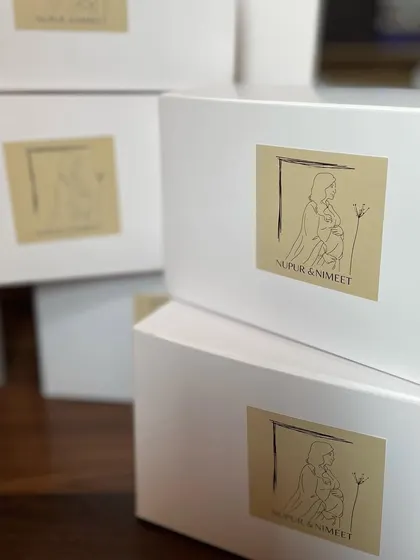 The simple and elegant white boxes used for the baby shower hampers, each with a custom sticker.