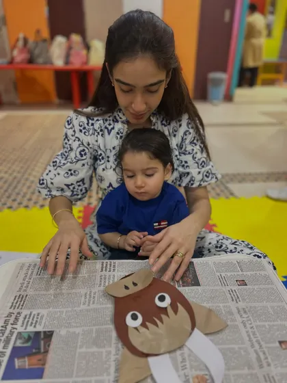 A mother and child work on a walrus craft, another example of how we integrate learning about animals and letters into our creative sessions.