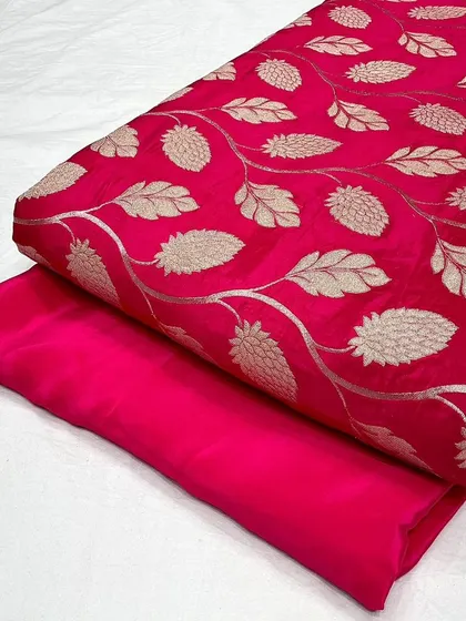 A closer look at the rani pink designer jacquard and plain crepe silk set. The smooth feel of the crepe complements the textured jacquard, offering a balanced and premium feel.