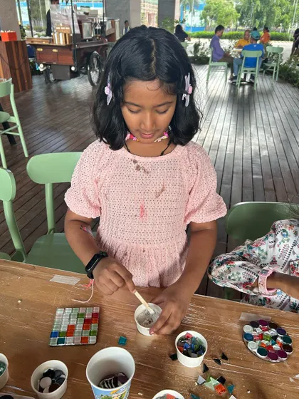 A young participant learning how to mix grout for her mosaic art piece at our pop-up.