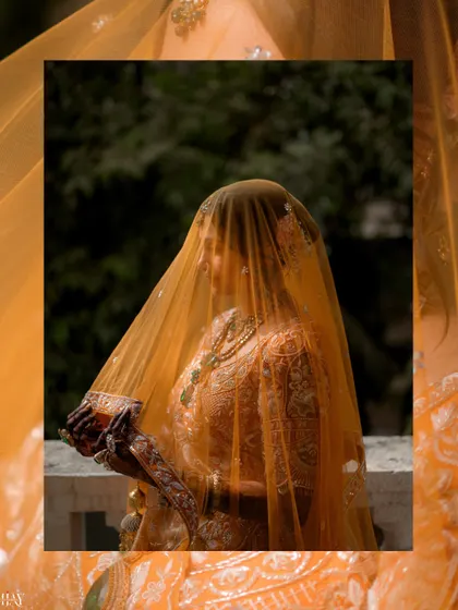 A creative shot of the bride veiled by her dupatta, creating a sense of mystery and elegance.