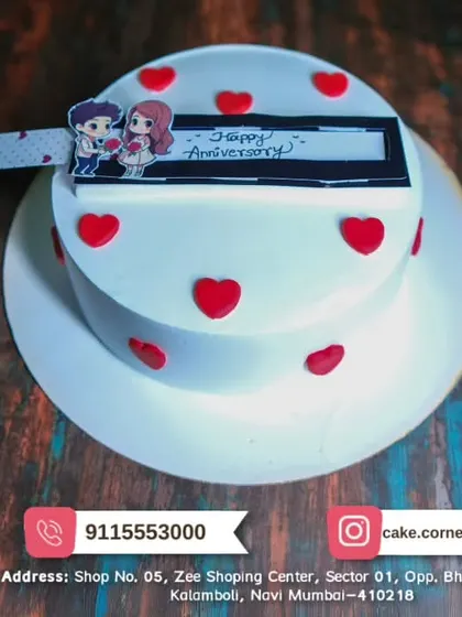 A simple and sweet anniversary cake with a cute couple topper and red hearts. A lovely way to celebrate another year together.