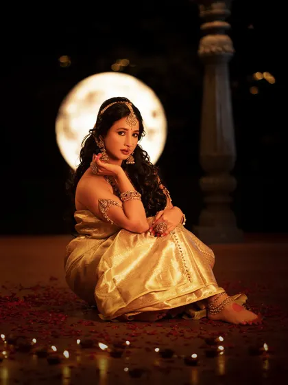 A stunning photo of actress Manvita Kamath from the "Viraha" themed shoot. The moon in the background and the scattered diyas create a magical and romantic atmosphere.