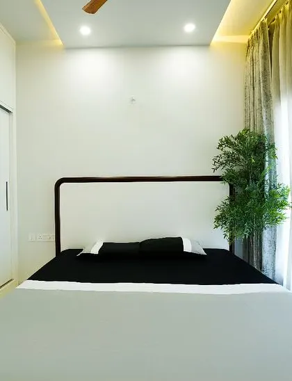 This view highlights the room's functional design, with a sleek white sliding wardrobe that maximizes space while maintaining the clean, minimalist aesthetic.