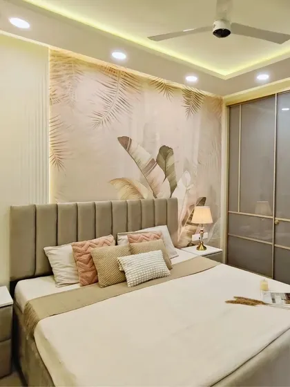 A luxurious bedroom that balances drama and serenity. A statement botanical wallpaper is paired with sleek grey wardrobes, cozy beige tones, and vibrant pink accent pillows.