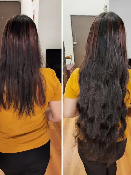 Here, we added extensions with subtle red highlights to match the client's existing color, while also adding significant length and soft waves.