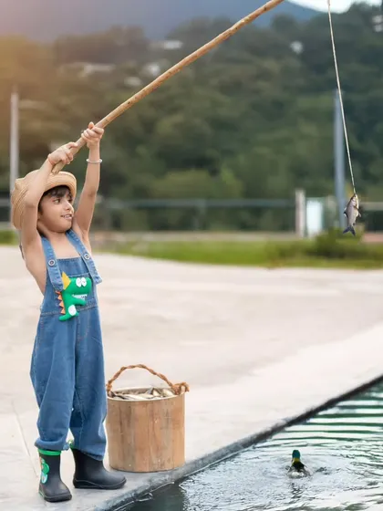 A perfect day for fishing! This outdoor themed shoot captures the simple joys of childhood, with a toy fishing rod, a bucket, and a beautiful natural backdrop.