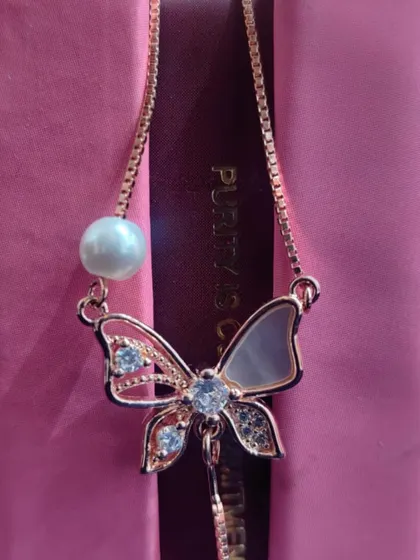 A beautiful rose-gold butterfly pendant with mother-of-pearl wings, a unique and enchanting piece.