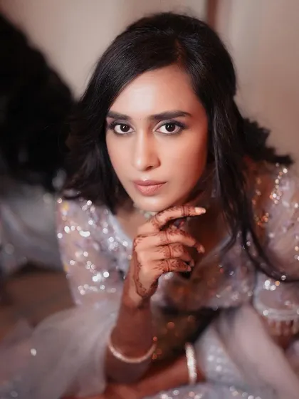 A close-up portrait of the bride in her sequined lehenga, her direct gaze creating a captivating image.