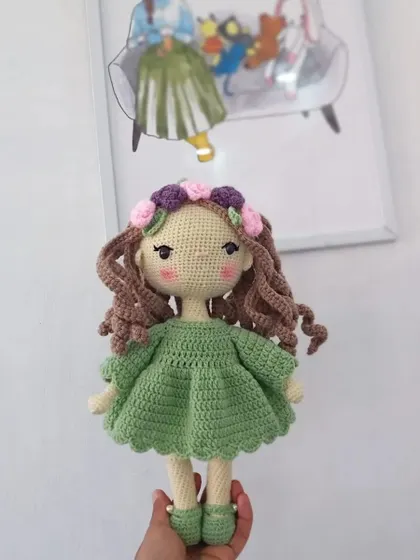 A still photo of my original doll design with a flower crown and a lovely green dress, perfect for anyone looking for a unique handmade gift.