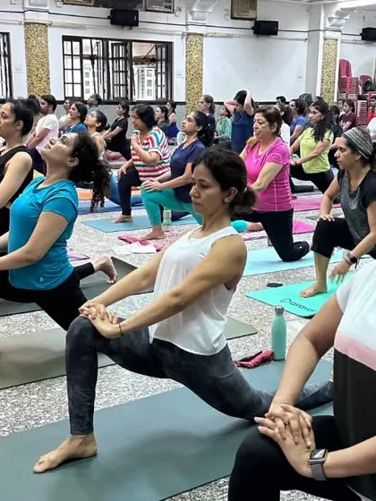 A sea of practitioners in Ashwa Sanchalanasana (Equestrian Pose) during our community event.