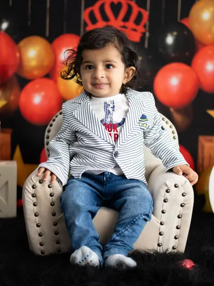 A classic portrait from the king-themed shoot, showing off his cool striped blazer and confident pose.