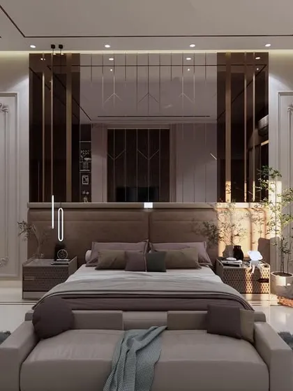 A master bedroom from our Krishna Vilas project, blending modern and classical elements. The room features a large bed with a mirrored headboard, a cozy seating nook, and a built-in study area.