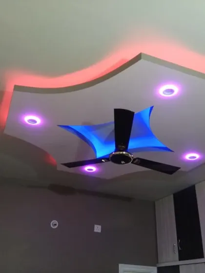 This custom-shaped false ceiling is enhanced with dual-color LED backlighting. The design allows for a vibrant, playful ambiance with options for different color combinations to suit any mood.