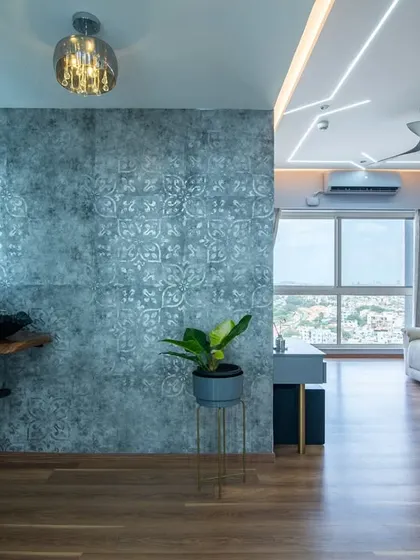 A view showing the connection between the living area and a stylish vanity corner. The consistent use of a cool, textured wallpaper and wooden flooring ties the different zones together seamlessly.