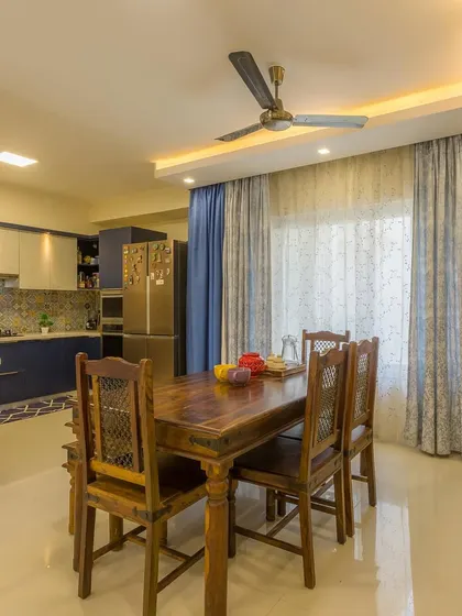 The open-plan layout connects the living room to the dining area, which features a classic wooden dining set.