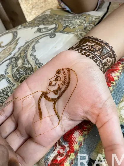 The outlining continues, focusing on the bride's attire and the delicate details of her hands. You can see the portrait coming to life.