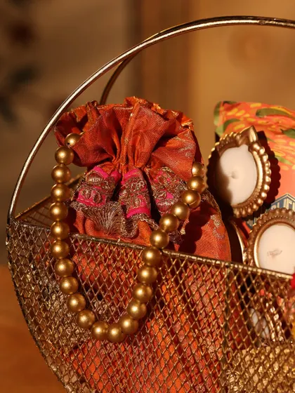 This shot highlights the beautiful orange brocade potli bag and pearl necklace detail in one of my traditional Diwali hampers.