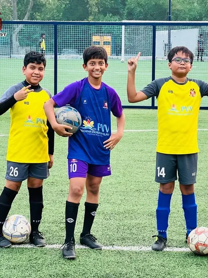 Find your moment and celebrate it. Three young players pose after a successful training session, living the dream on the pitch.
