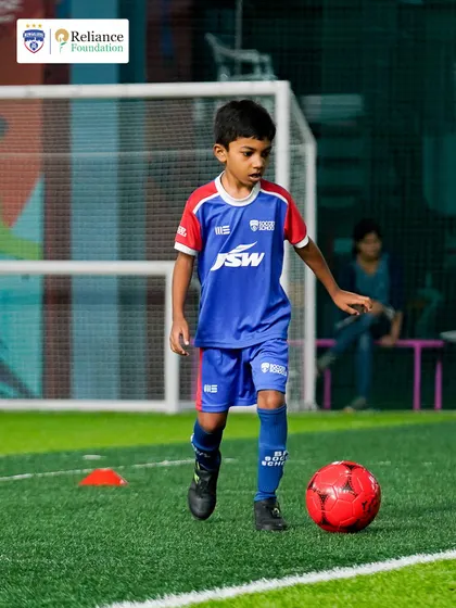 A young player practices dribbling with precision. Our drills are designed to build confidence on the ball, encouraging players to take on opponents.