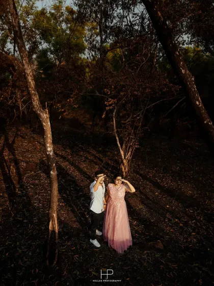 An aerial shot of a couple walking through a forest, with dramatic shadows cast by the trees. This high-angle perspective creates a unique and artistic composition.
