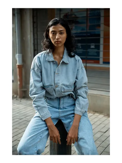 A straight-on portrait that is simple yet powerful. The focus is entirely on the model's expression and the texture of the denim.