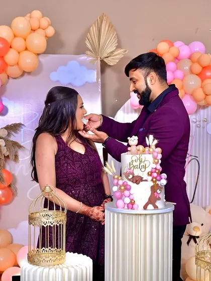A beautiful moment captured as the parents-to-be cut their cake. Our 'Baby in Bloom' decor, with its organic balloon arch and custom backdrop, provides the perfect setting for these cherished memories.