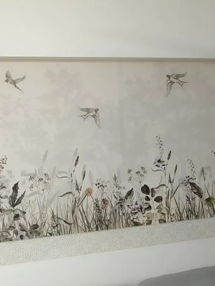 A delicate wildflower and meadow scene with flying birds. This type of serene wallpaper is perfect for creating a restful environment in a bedroom.
