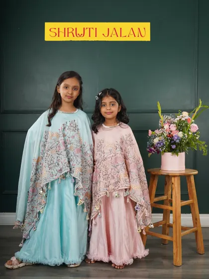 Two sisters looking ethereal in my flowing cape sets. The soft pastel colors and delicate floral prints make these outfits a dreamy choice for any special occasion.
