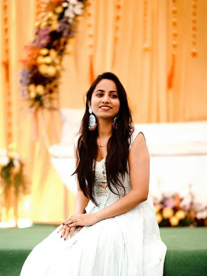 A guest enjoying the Mehendi function. Our decor setups, like this one with a floral swing and bright drapes, are designed to be beautiful from every angle.
