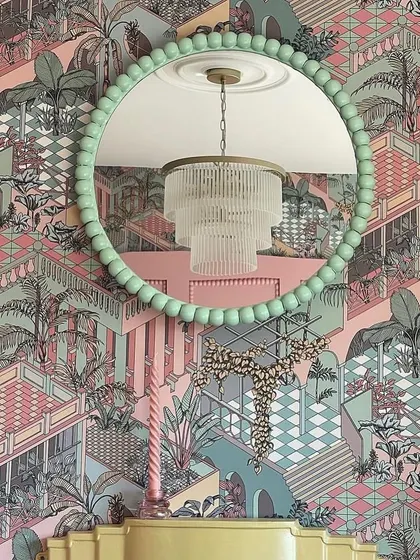 The 'Miami' wallpaper by Cole & Son, with its layers of terraced colonnades and lush foliage, creates a backdrop of tropical exuberance. The design's mid-century deco glamour is a testament to playful yet sophisticated style.