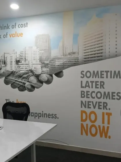 I combine powerful quotes and cityscape graphics to create a dynamic and motivating atmosphere in this corporate meeting room. The design reinforces key business messages like "Think of value" and "Do it now" to drive performance.