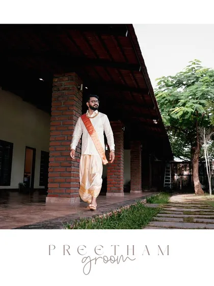 A stylish portrait of the groom in his traditional dhoti, walking with confidence on his wedding day.