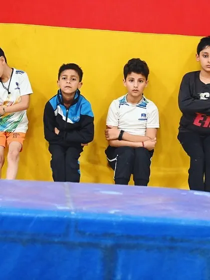 A group of young boys waiting for their turn, focused and ready for the next drill.