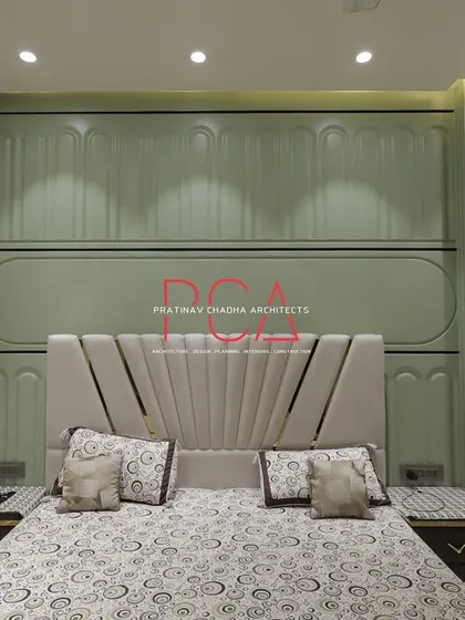 The master bedroom in The Cursive Abode, with a custom bed set against a sage green wall with neoclassical-inspired paneling. The design creates a tranquil and elegant retreat.