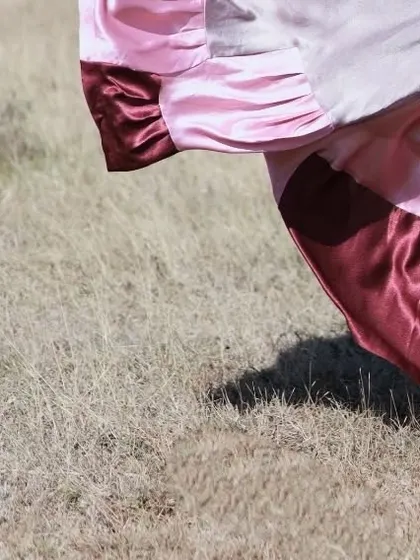 An abstract shot of the skirt's hem on the dry grass.