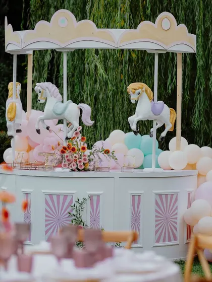 The stunning carousel cake station, complete with model horses and surrounded by pastel balloons.