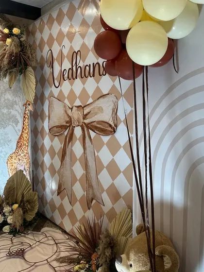 A detailed shot of the earthy and whimsical boho decor. The combination of the custom backdrop, balloon colors, and teddy bear props created an enchanting setting for the naming ceremony.