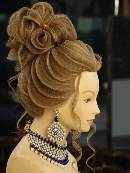 A beautiful high bun combining a rose bud element with fashionable lines. This is a very creative and artistic updo, perfect for a bride who wants a unique style.