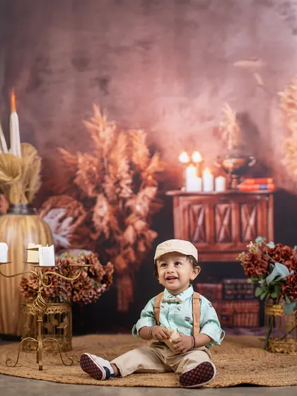 A moment of pure joy in a rustic setting. This little boy's happy expression lights up the warm, candle-lit room, creating a beautiful and timeless portrait.