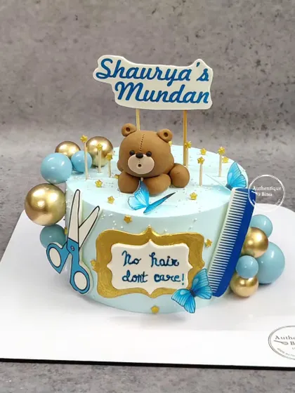 A special cake for a Mundan ceremony. This blue cake is decorated with a teddy bear, scissors, and a comb, with a fun "No hair, don't care!" message.