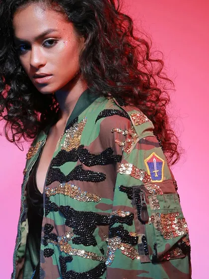 A close-up on the embellished camo jacket, highlighting the detailed sequin work that makes the piece unique.