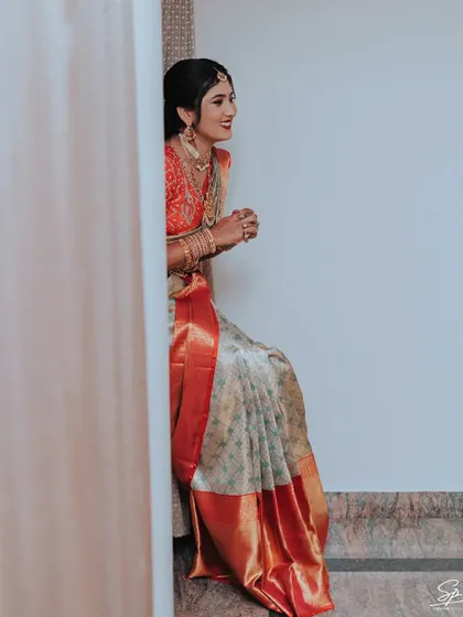 A quiet, candid moment of the bride waiting, captured from a creative angle.