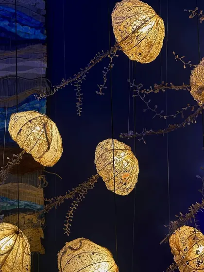 An intricate lighting installation made of gilded, pod-like forms. This piece showcases a beautiful combination of natural inspiration and refined craftsmanship.