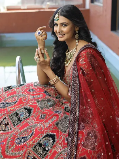 A happy bride enjoying her moment in our red and black embroidered lehenga. Renting allows you to wear such a heavily detailed and unique piece for your special day without the hefty price tag.