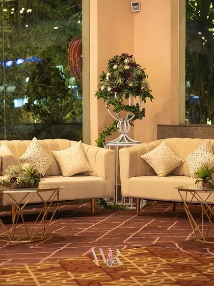 A cozy lounge setting with neutral-toned sofas and geometric gold coffee tables. This space provided a quiet, comfortable retreat for guests within the larger event.