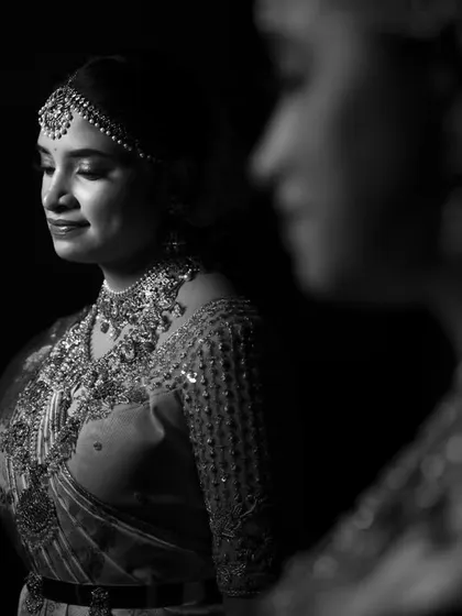 A creative black and white portrait using a reflection. The bride is seen in sharp focus while her reflection is soft, adding depth and an artistic touch.