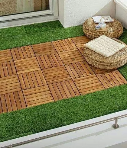 A minimalist yet cozy balcony floor design. The combination of high-quality artificial turf and interlocking wooden deck tiles creates a defined, stylish area for seating and relaxation.